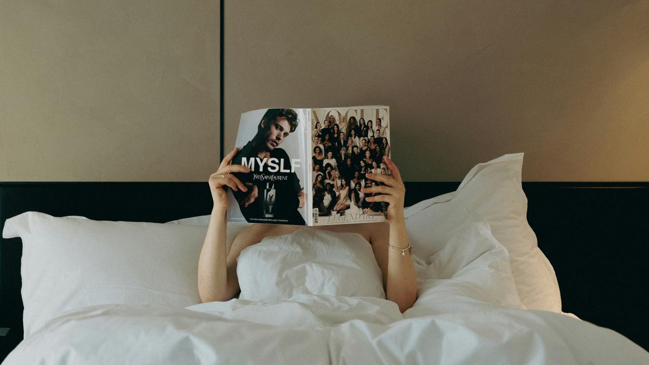 a person laying in bed reading a book