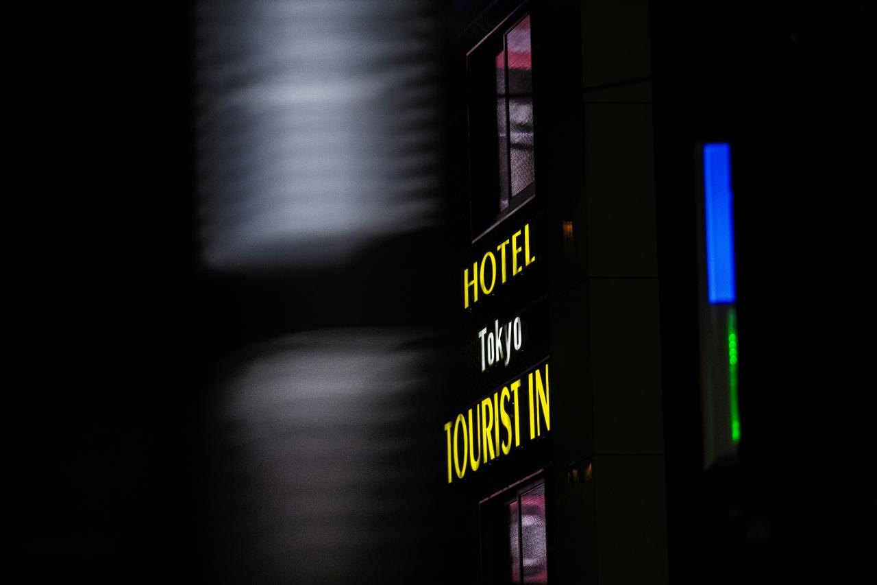 a hotel sign is lit up in the dark
